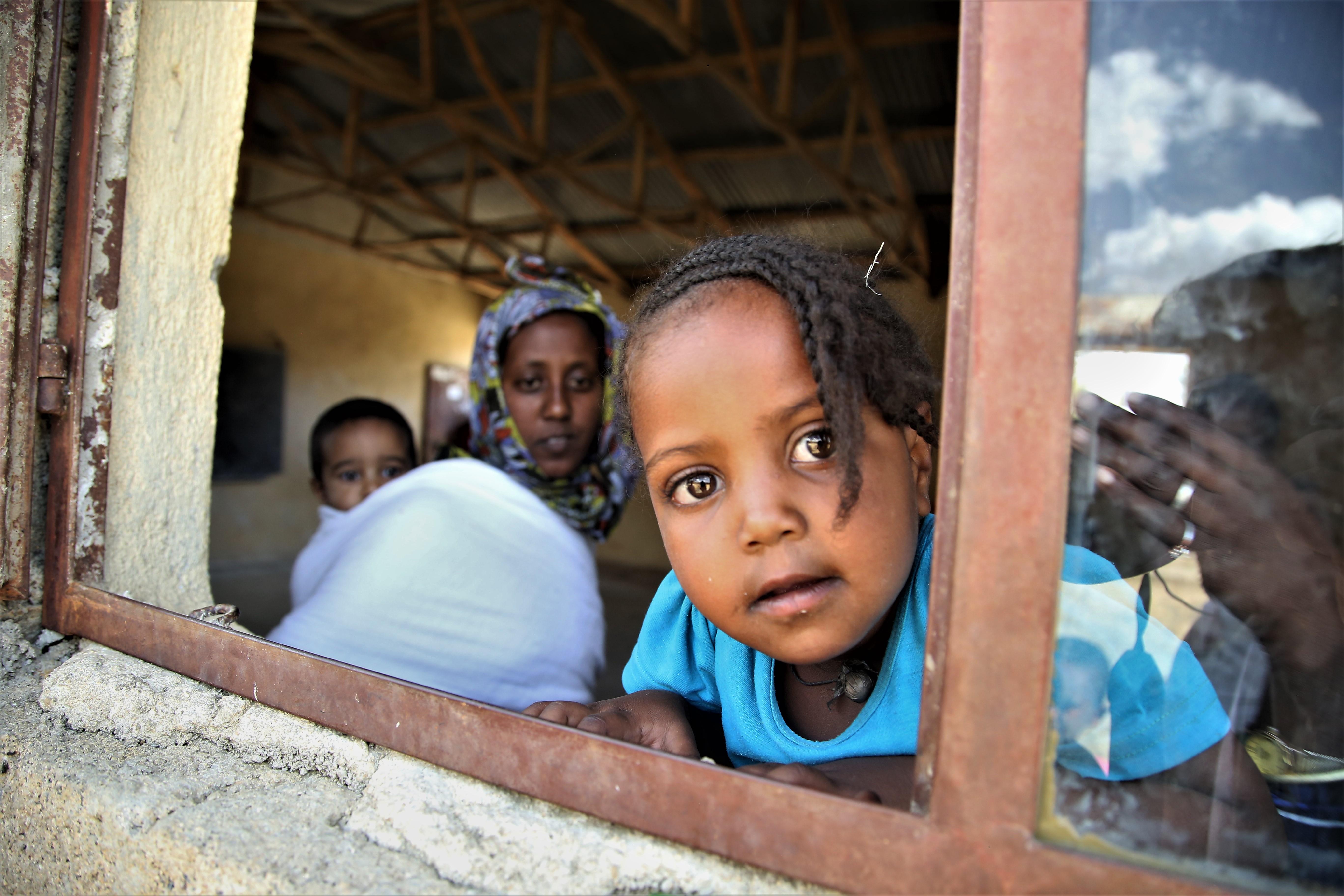 A displaced woman and her children stand at Abdimalaha school, Adwa, a town in central Tigray. 2021