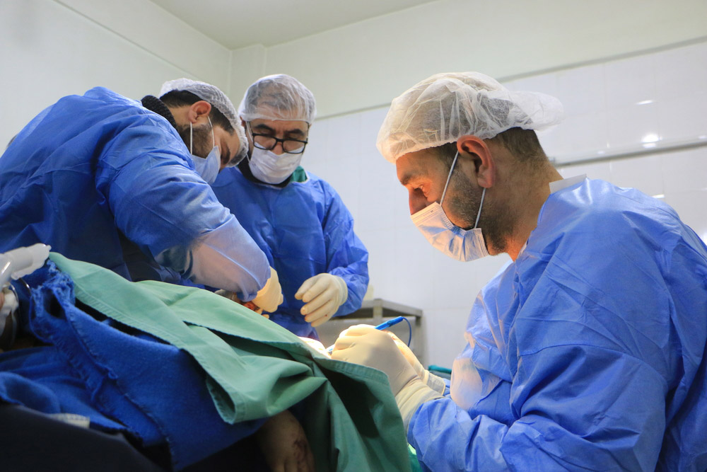 Syrian doctors operate on a patient in a hospital in Atmeh