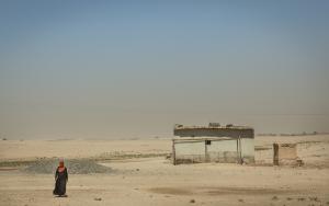 A woman walks in the desert, not far from her house.
