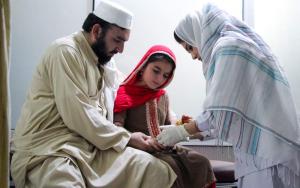 A young patient with her father receiving an injection for cutaneous leishmaniasis in Pakistan