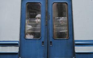 UKRAINE. Lviv. 26 February 2022. Children seen through the window of an evacuation train traveling towards the border with Poland as thousands of people try to escape the on-going conflict in Ukraine. 