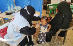 A picture of an MSF staff member giving a child a medical check up