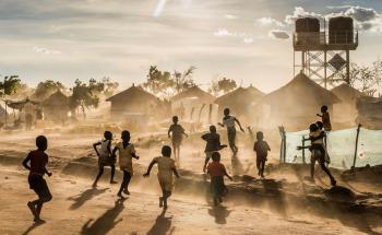 Children are playing in the Bidibidi camp. On the background we can see some shelters and the water tank provide by MSF.