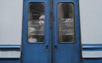 UKRAINE. Lviv. 26 February 2022. Children seen through the window of an evacuation train traveling towards the border with Poland as thousands of people try to escape the on-going conflict in Ukraine. 