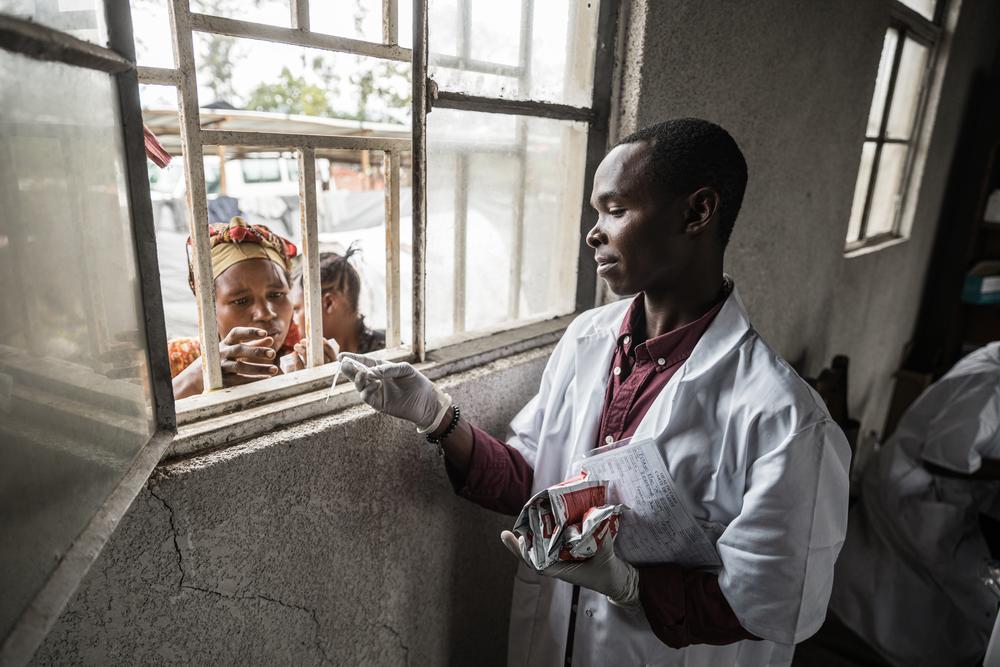 Image of an MSF staff member distributing nutritional food in Rusayo, Democratic Republic of Congo