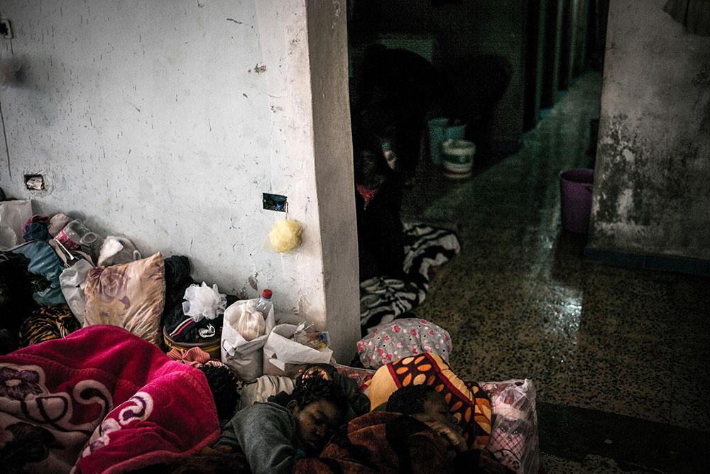 Women detained at female-only Sorman detention centre, around 60km west of Tripoli, Libya. Access to water for washing is one bathroom with a few showers. Overcrowded main room means that detainees also have to sleep on the bathroom floor.