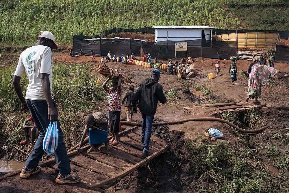 Displaced people at a water point in Rhoe camp. As a result of successive attacks in the region, more than 40,000 additional people have been forced to take refuge in the Rhoe site in 2 months, bringing its population to more than 65,000 displaced. MSF increased its WASH (Water, sanitation and Hygiene) activities to provide clean water and latrines to the population the camp.