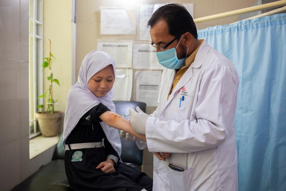 MSF’s nursing care provider Abdullah Shah cleans the lesion of Mariam. Mariam, 12, visits the MSF’s clinic at Benazir Bhutto Hospital in Quetta district after school along with her father. Pakistan, 18 May 2022.