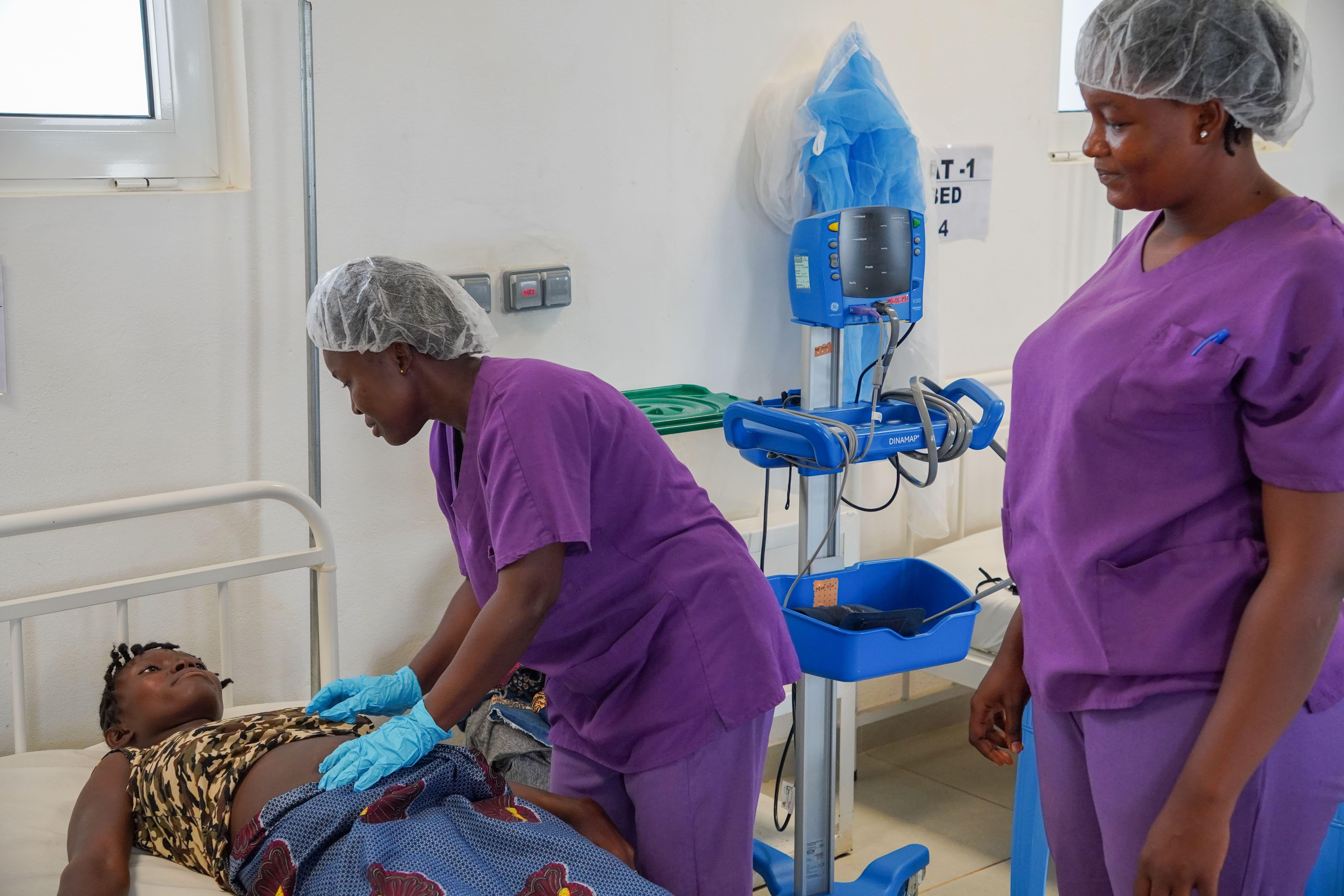 Sierra Leone Midwifery:Midwives checking on a postpartum patient at Kenema hospital. They are participating in the MSF Academy for Healthcare's Midwifery clinical care training programme