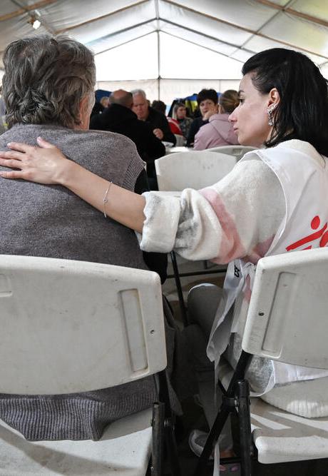 A psychologist comforts a woman who was displaced in Ukraine.