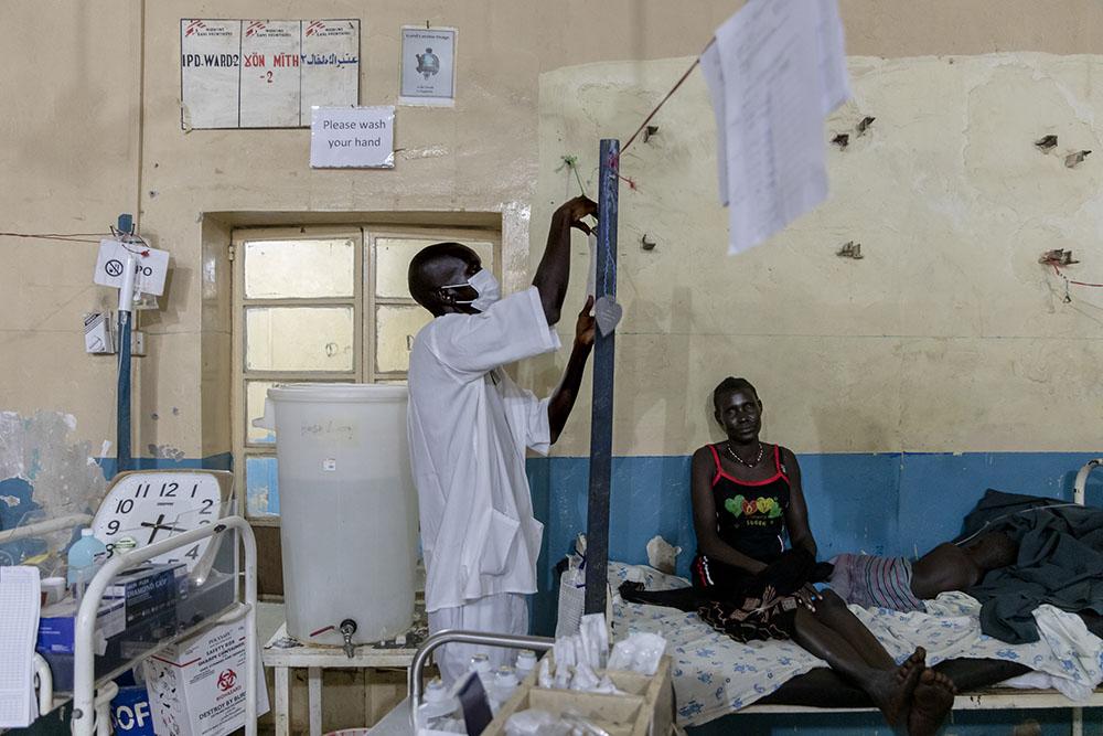 Atong Dut Deng, 8 years old, infected with cerebral malaria. She is being attended to by MSF medical staff in the ICU at MSF supported Aweil State Hospital. She is accompanied by her grandmother Rebecca Achol Atak (age unknown). South Sudan, October 26th, 2021. 