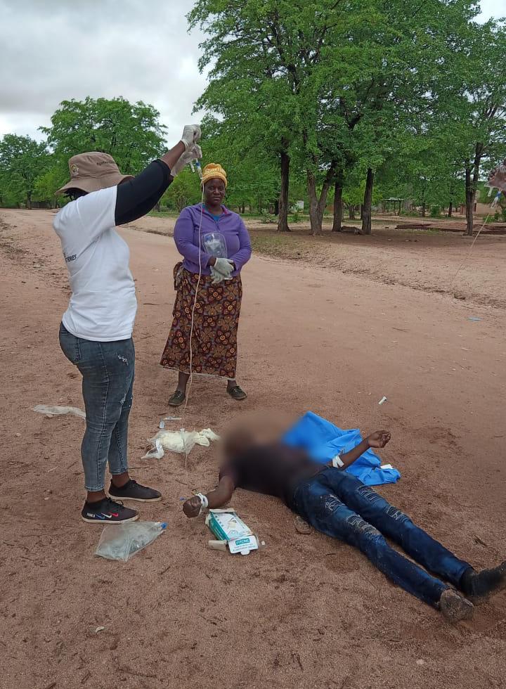 MSF staff treating a cholera patient in a scotch cart on the road side in Zimbabwe