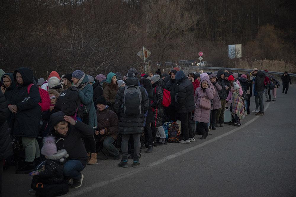 Hundreds of people wait in line to cross the border on foot into Slovakia from the city of Uzhhorod in Ukraine's Transcarpathia region, March 6, 2022