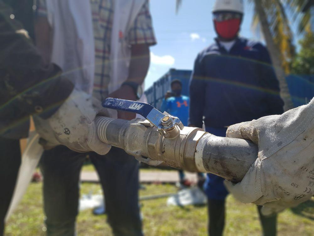 Tubes are connected allowing water to flow between the newly drilled hole and the hose. 